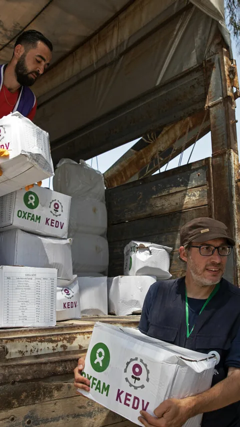 Hulpverleners laden noodhulppakketten uit een vrachtwagen.