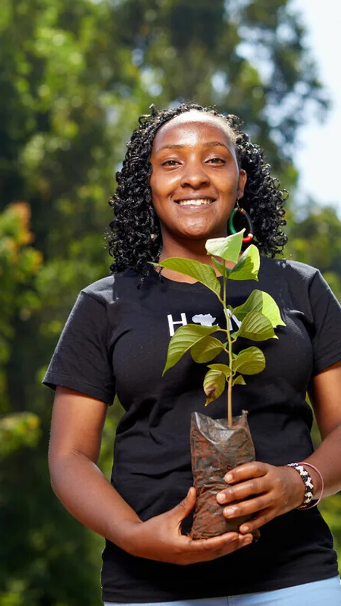 De Keniaanse klimaatactivist Elizabeth Wathuti met een boompje in haar hand