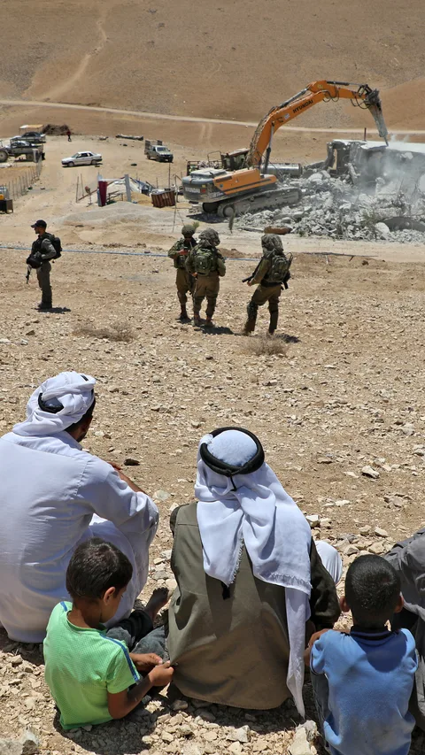 Bewoners kijken toe hoe Israëlische bulldozer een Palestijns huis sloopt
