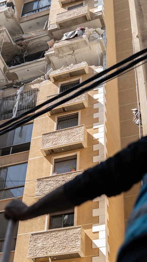 Arbeiders ruimen puin op na een Israëlische luchtaanval op een appartementencomplex in de wijk Aisha Bakkar in het centrum van Beiroet, waarbij slachtoffers vielen en nabijgelegen huizen en auto's beschadigd raakten, in Beiroet, Libanon, 11 maart 2026.